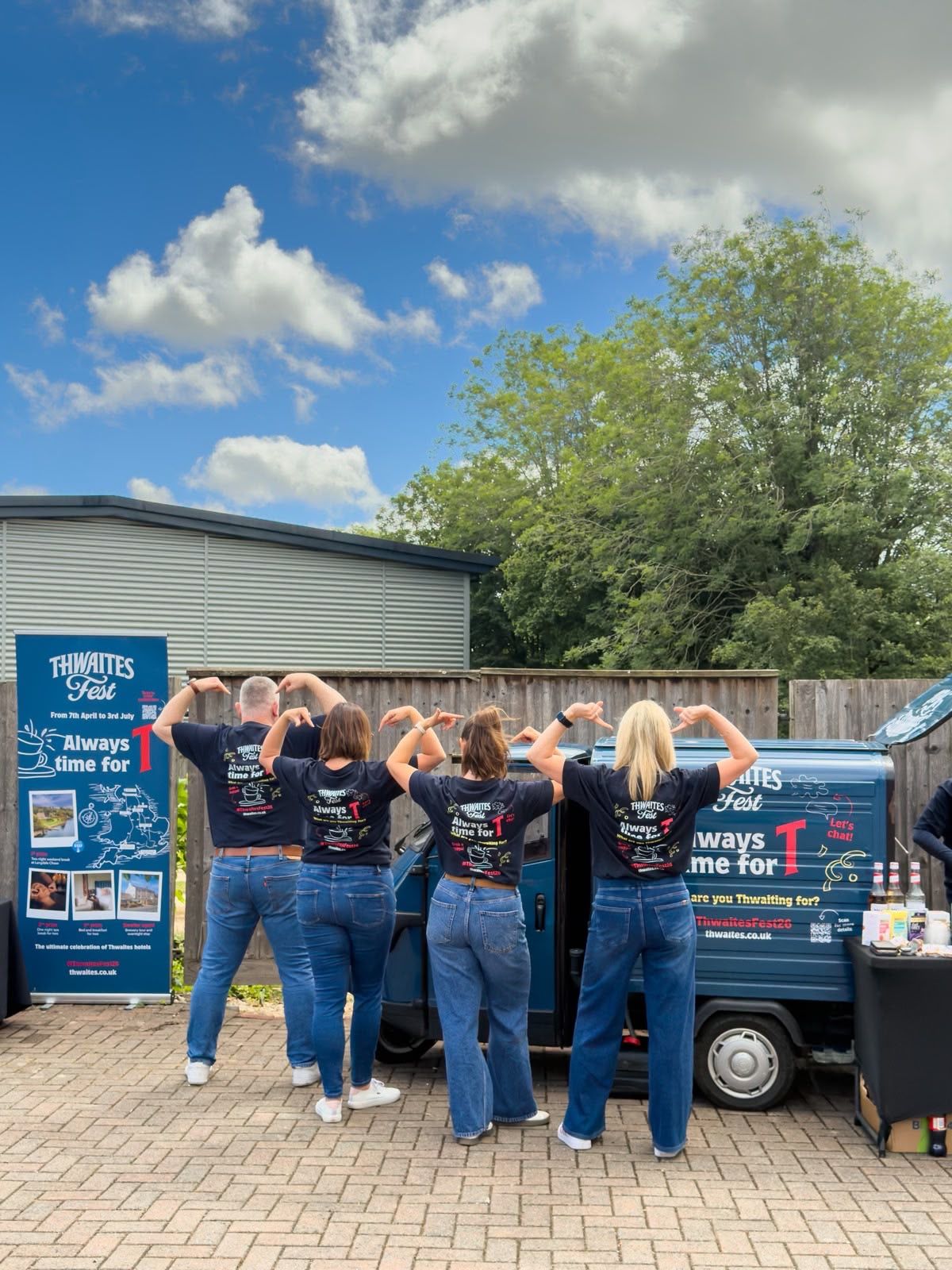 Staff photo outside of tea truck with Thwaites Fest t-shirts on