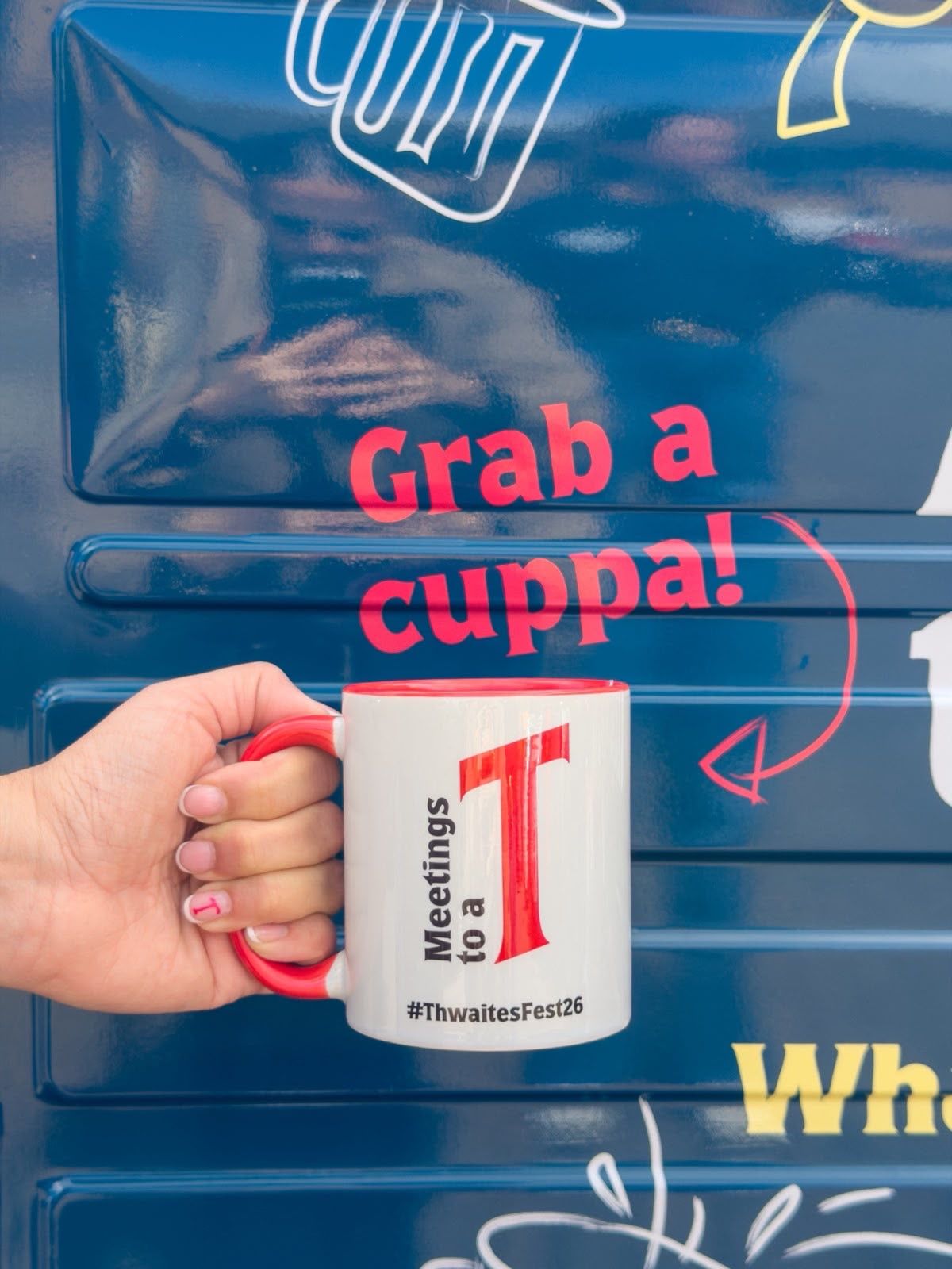 Grab a cuppa Thwaites Fest mug next to tea truck van
